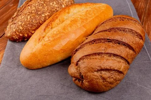 Side view of breads as vietnamese and black seeded baguette and black bread o Stock Photos