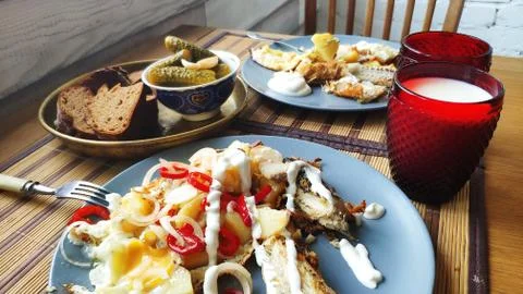 Side view breakfast for two, baked fish and potatoes with pickles, English br Stock Photos