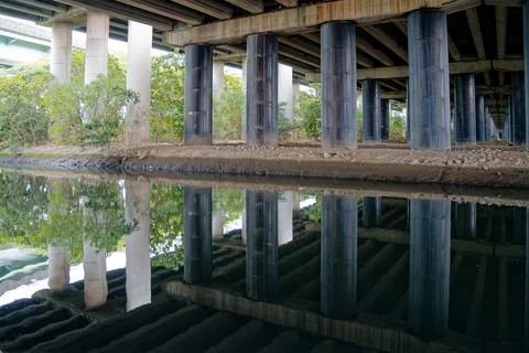 Side View of Bridge Pillars With Mirror Reflection on Tranquil Canal Water Stock Photos