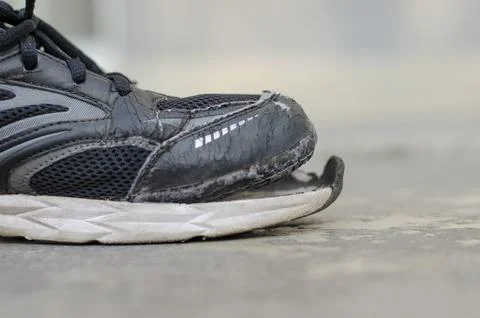 Side view broken old black canvas shoes on the floor. copy space Stock Photos