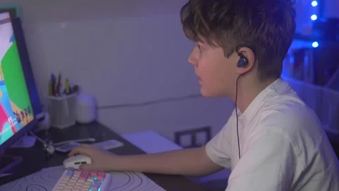 Side view, Brunette boy playing computer game online at home Stock Footage 305649939