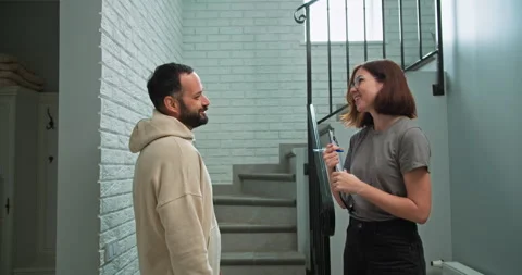 Side view of a brunette guy with a beard talking to a realtor girl who is Stock Footage 280642251