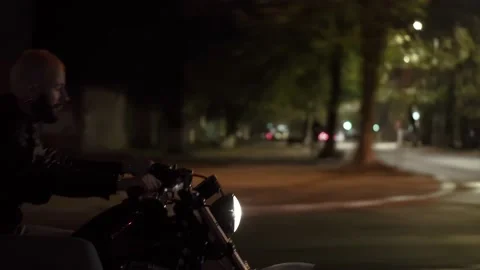 Side view of a brutal man riding fast his motocycle by night city street Видео 146781643