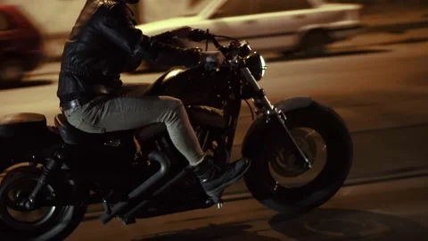 Side view of a brutal man riding fast his bike by night city street, close up of Stock Footage 146782091