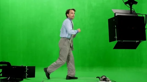 Side view of a businessman with suit jacket in hand runs in chromakey studio Stock-Footage 77827832