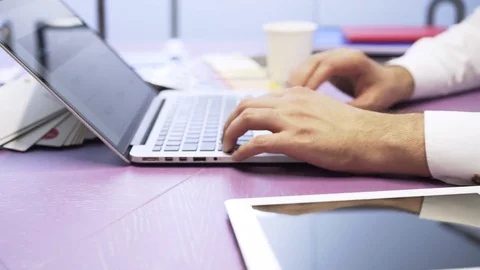 Side view of a businessman typing while his colleague is making a blueprint Stock-Footage 80351833