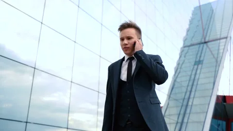 Side view businessman walking with mobile phone near building. Smiling busine Stock Footage 138948686