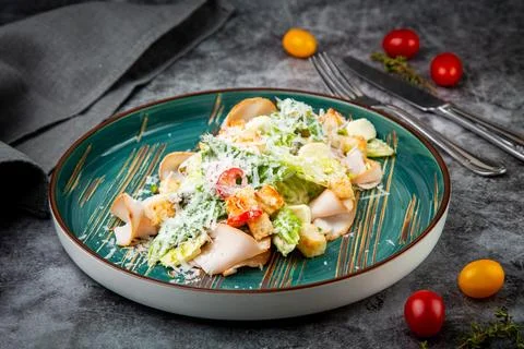 Side view of caesar salad with cheese on a blue plate Stock Photos