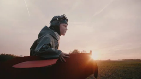 Side view camera follows happy little pilot boy in fun plane costume running in Stock Footage 99691304
