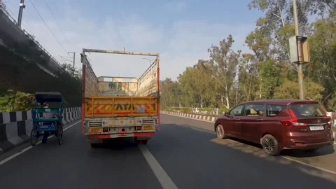 Side-view camera follows a Tata truck driving on a highway delhi Stock Footage 140878068