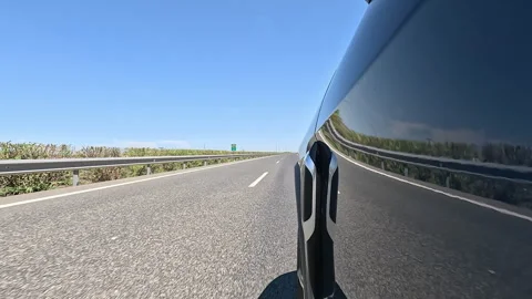 Side view of a car driving on an highway under clear blue sky Video stock 332065194