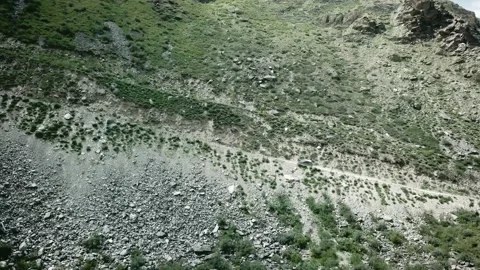 Side view of a car going up an earthen road on a hill from bottom to top. Scene Vidéo 136571893