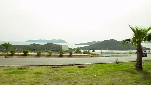 Side view from a car with sea and mountains in background. Stock Footage 74970231