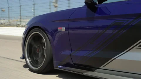 Side view of car speeding on racetrack Stock Footage 191312336