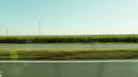 Side view from car window moving fast on blur highway, passing green fields, Stock-Footage 342919311