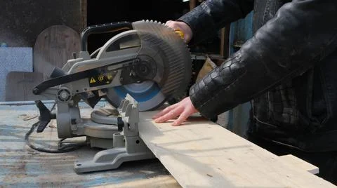 Side view of a carpenter using a miter saw Stock Photos