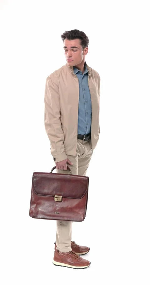 Side view of casual man with suitcase holding hand in pocket and talking in a Stock Footage 304830027