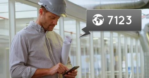 Side view of a Caucasian engineer standing outside an office holding plans in Stock Photos