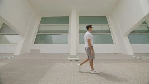 Side view of caucasian man feeling smart and confident while walking outdoors Stock Footage 235392863