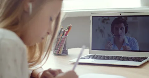 Side view caucasian primary school girl wearing headphones look at laptop screen Stock Footage 142393272