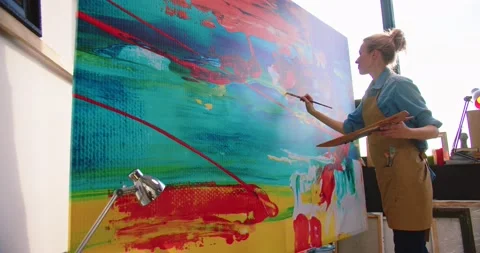 Side view of Caucasian young pretty talented female painter working in art Stock Footage 149572638
