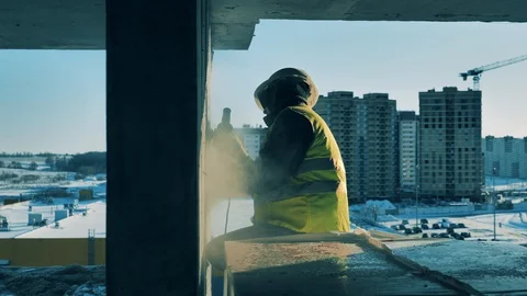 Side view of a cement wall getting buffed by a male worker Video stock 129382430