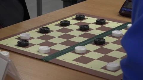Side view of checkers pieces moving across a board with small intervals. Stock-Footage 332807440