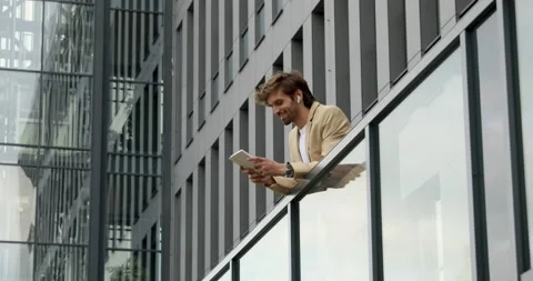 Side view of cheerful bearded man in business suit standing on balcony of office Stock Footage 137744229