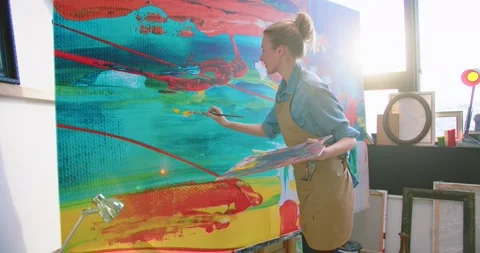 Side view of cheerful smiling young beautiful Caucasian female painter drawing Stock Footage 149572817