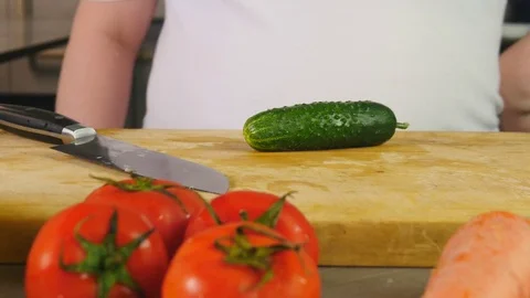 Side view chef cuts the cucumber into half-rings on a cutting board Stock Footage 76088182