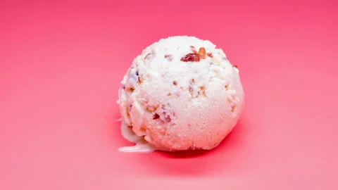 Side view chestnut and red bean ice cream ball melting timelapse on pink Stock Footage 107717702