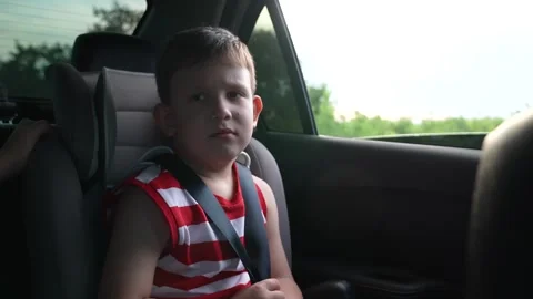 Side view of a child gazing out from a car, open window, reaching for the world Stock Footage 313906904