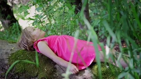 Side View Of A Child Laying On A Log In The Forest, She Is Looking Up Peacefully Stock Footage 42009157