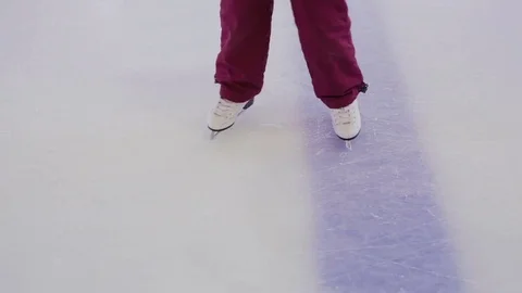 Side view at children's legs in white skates. Riding on the ice. Video stock 70794784