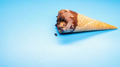 Side view  chocolate ice cream cone melting timelapse on blue background Stock Footage 108492557