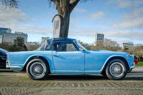 Side view of classic Triumph TR4 sports car on cobblestone road Stock Photos
