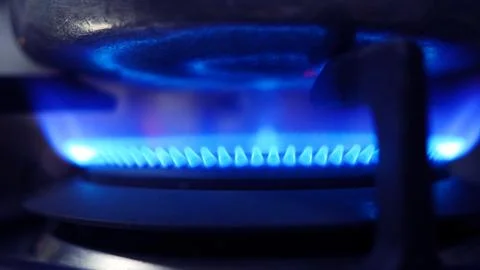 Side view close up blue flame fire from gas stove burner 库存照片