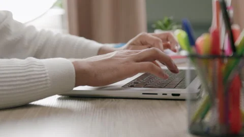 Side view close-up of a boys hands typing on a computer keyboard. Office table Stock Footage 316089907