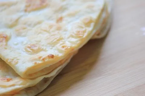 Side view close up of crispy stacked homemade flatbread resting on a smooth.. Fotos Stock