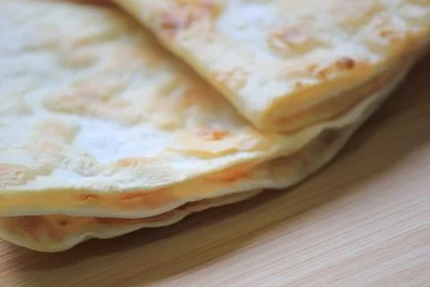 Side view close up of crispy stacked homemade flatbread resting on a smooth.. Stock Photos