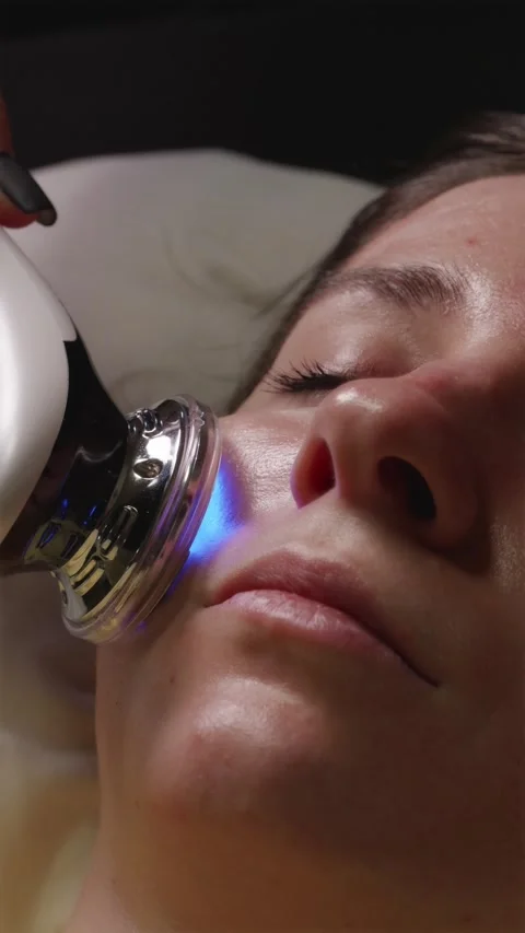Side view close up of facial microcurrent therapy with blue light beauty devi Video stock 344877047