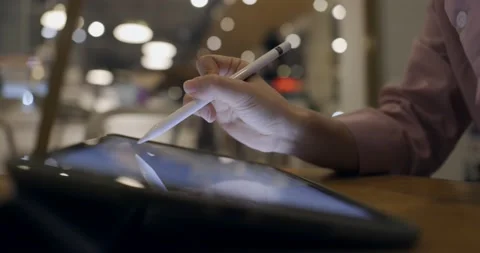 Side view, close up of a female hand using digital tablet with a pen while wo Stock Footage 233596007