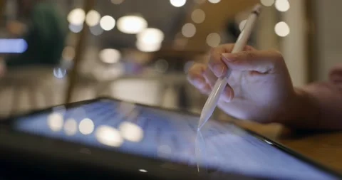 Side view, close up of a female hand using digital tablet with a pen while wo Stock Footage 233596068