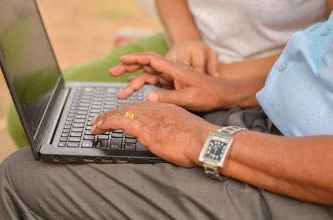 Side view close up of hands of an young Indian girl teaching old man Stock Photos