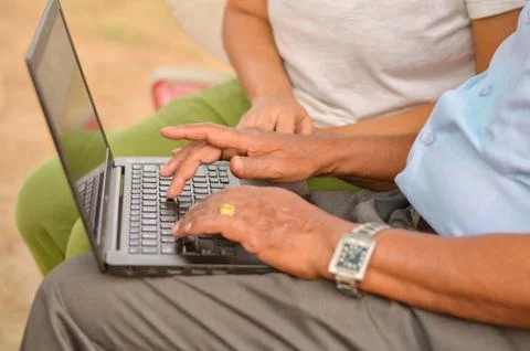 Side view close up of hands of an young Indian girl teaching old man Stock Photos