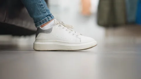 Side View Close-up of Lady's White Canvas Sneakers Gently Tapping Right Foot 스톡 동영상 301716676