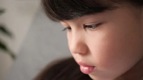 Side view close-up of little cute beautiful girl using her smart phone with Stock Footage 168536088