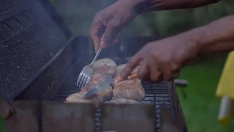 Side view close-up of male African American hands checking grilled meat on bbq 库存影片 154909861