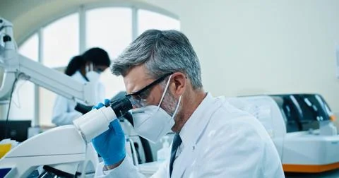 Side view. Close up of middle-aged Caucasian man medical scientist working in Stock Photos