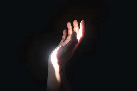 Side view close up of an open human hand reaching up towards dramatic high-.. Stock Photos